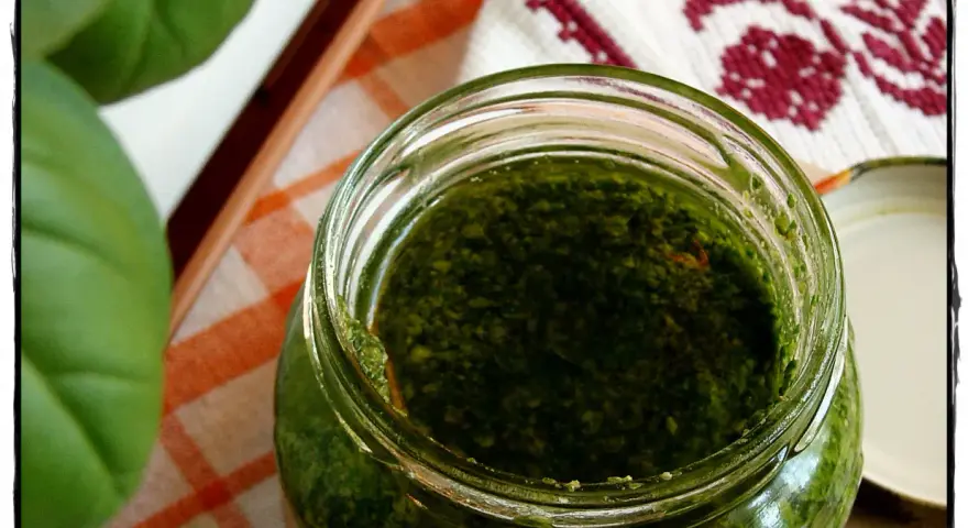 Słoik domowego pesto z bazylii, obok świeże liście. Idealne do makaronu!