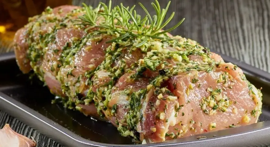 Schab w aromatycznej marynacie z czosnku, ziół i rozmarynu, gotowy do pieczenia.
