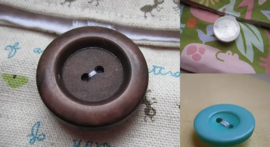 Gros plan sur un bouton à queue marron, prêt à être cousu sur un tissu orné de petites fourmis. Un autre bouton nacré est visible sur un tissu coloré.