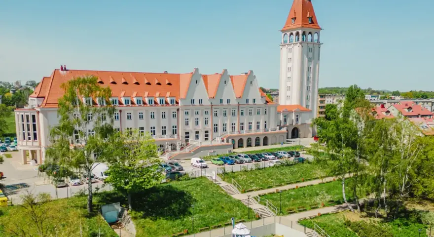 Władysławowo: okazały budynek z wieżą, dawny dom rybaka, otoczony zielenią i placem zabaw.