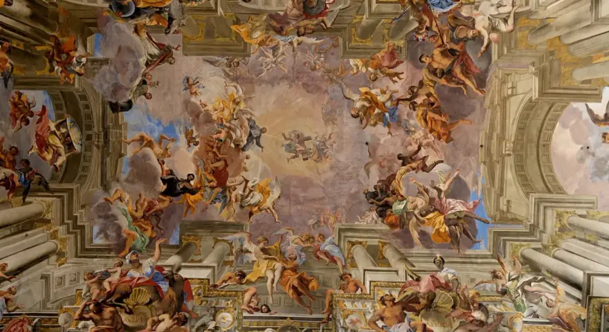 Un plafond spectaculaire dans le style baroque, peuplé d'anges et de figures célestes dans un tourbillon de couleurs et de mouvement.