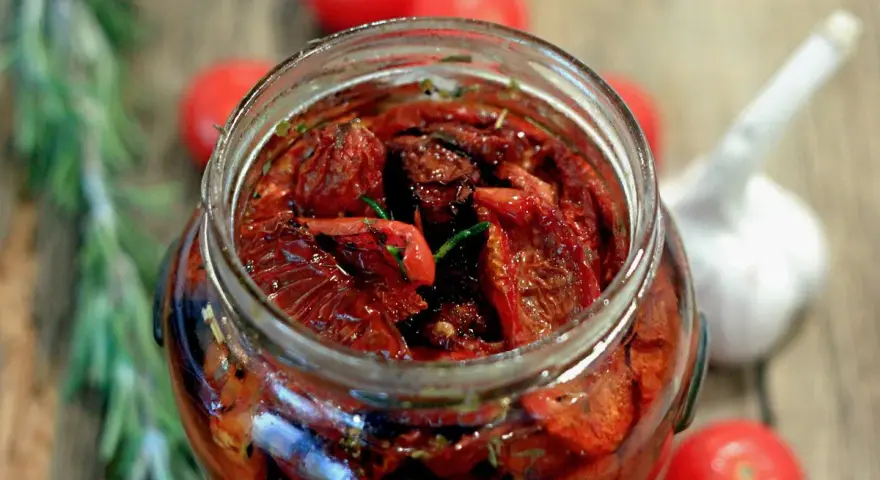 Pomodori secchi sott'olio, la ricetta della nonna. Un barattolo pieno di sole, profumato di rosmarino e aglio, pronto per insaporire ogni piatto.