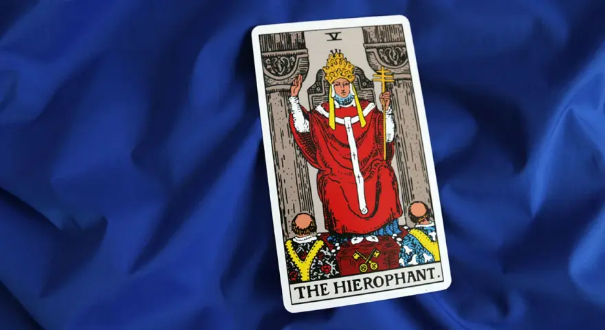Karta Tarota "The Hierophant" na niebieskim tle. Symbolizuje tradycję, duchowość i przewodnictwo.