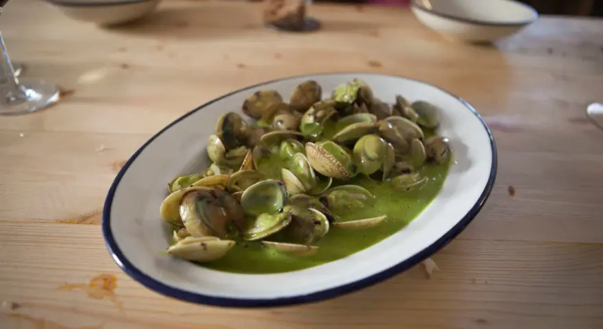 Deliciosas almejas en salsa verde, un plato que invita a saborear el mar.