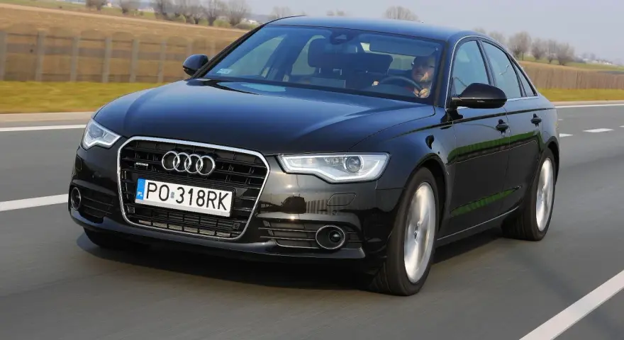Czarne Audi A6 C7 3.0 TDI Biturbo w ruchu drogowym.