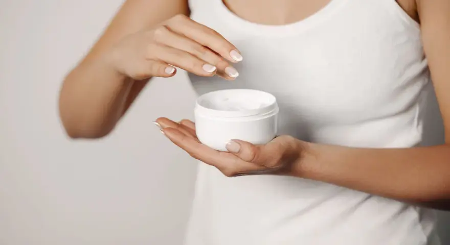 Manos aplicando crema para suavizar la piel y tratar la queratosis pilaris.