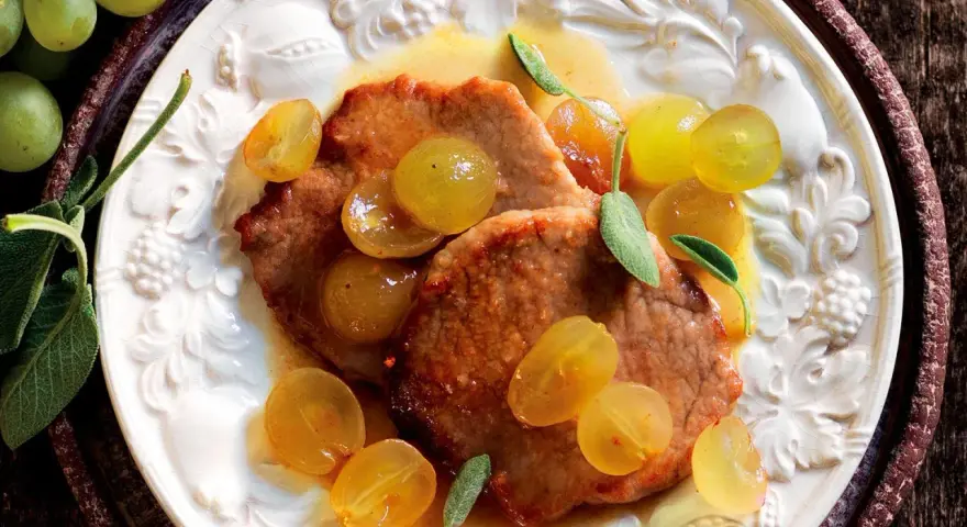 Scaloppine al vino bianco con uva dorata e salvia, un piatto succulento e profumato.