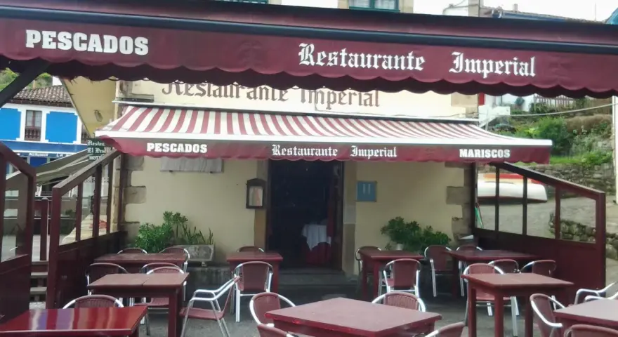 Mesas listas para comer en tazones en el Restaurante Imperial, especializado en pescados y mariscos.