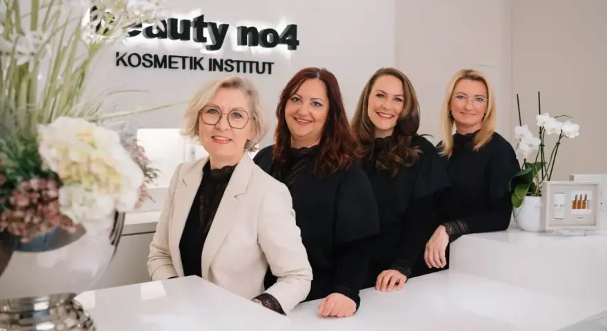 Vier freundliche Frauen im "Beauty no4 Kosmetik Institut" lächeln in die Kamera. Sie sind bereit, Ihnen mit Kosmetik und Wellness zu verwöhnen.