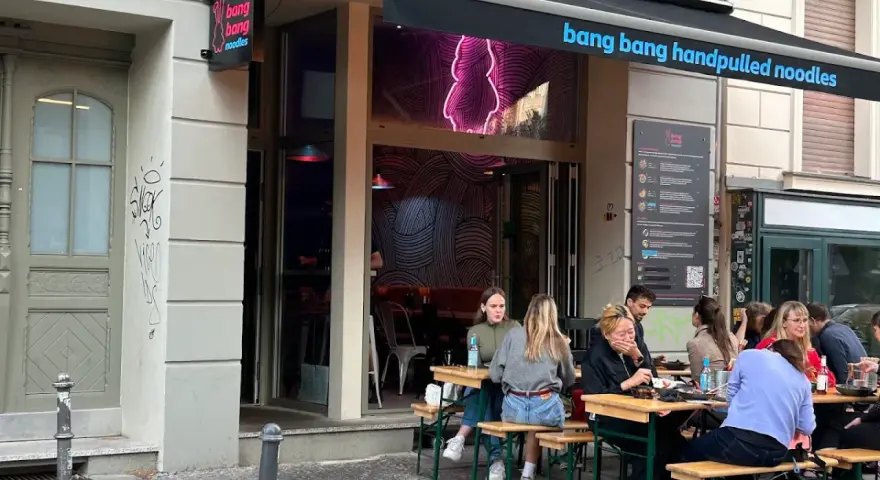 Menschen genießen das Essen vor dem Restaurant "bang bang noodles berlin".