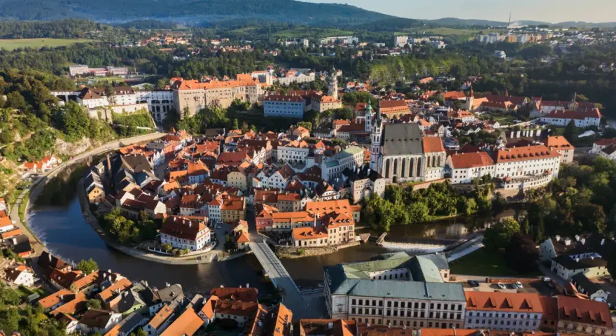 Widok na malowniczy Czeski Krumlov, gdzie rzeka Vltava otacza zabytkowe centrum z zamkiem i kościołem. To idealne miejsce, by odkrywać czeski krumlov atrakcje.