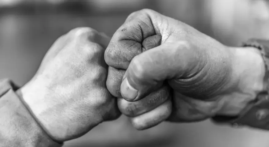 Zwei Fäuste stoßen zusammen, ein Zeichen von Solidarität und Verbundenheit.