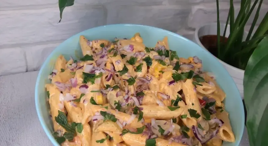 Penne z sosem gyros, kukurydzą i czerwoną cebulą, posypane natką pietruszki. Pyszna sałatka gyros z makaronem.