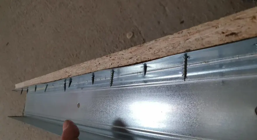 Schrauben verbinden OSB-Platte mit Metallprofil. Rigips auf OSB schrauben ist der nächste Schritt.