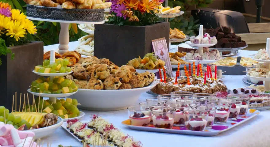 Vielfältige Brunch Ideen: Croissants, Scones, Obstspieße, Brownies und süße Desserts in Gläsern laden zum Genießen ein.
