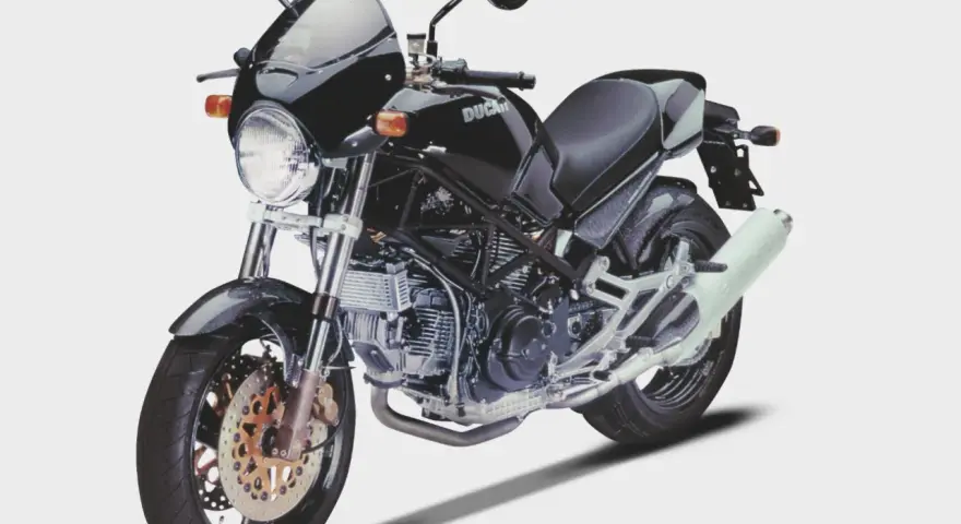 Czarny Ducati Monster z owiewką i sportowym wydechem. Klasyka motoryzacji, która wciąż budzi emocje.