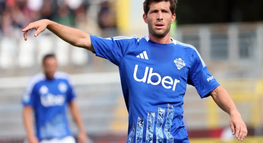 Sergi Roberto, con camiseta azul del Como, señala con el dedo en un partido.