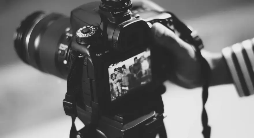 Dłoń trzyma aparat, gotowa do uchwycenia chwili. Może to być moment z życia gwiazdy, który trafi na okładkę, albo praca paparazzi w akcji.