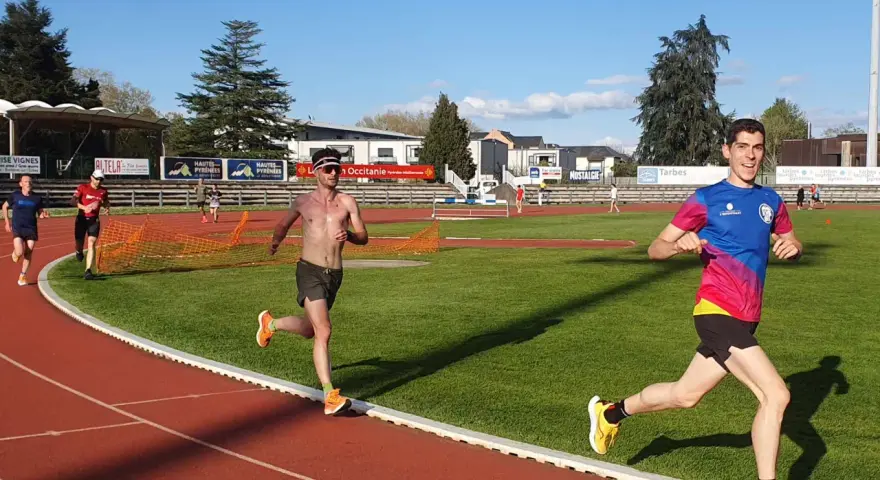 Coureurs sur piste, s'entraînant pour savoir combien de jours de repos avant une compétition. Le soleil brille sur la piste d'athlétisme.