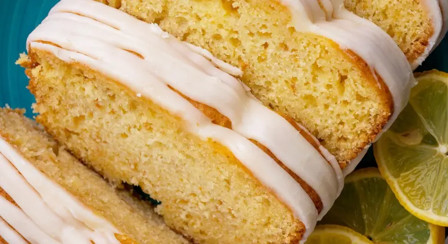 Saftiger Zitronenkuchen mit Zuckerguss, perfekt für einen sonntagskuchen schnell und einfach. Dazu frische Zitronenscheiben.