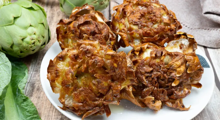 Un piatto di croccanti carciofi alla giudia, dorati e salati, pronti per essere gustati.