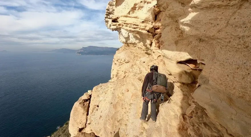 Grimpeur au **Cap Canaille**, face à la mer Méditerranée, prêt pour l'aventure sur les falaises calcaires.