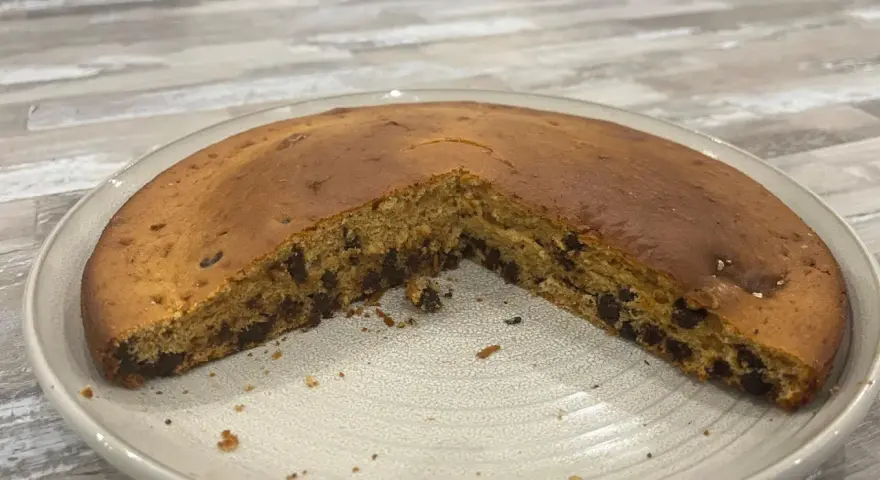Gâteau chocolat compote, moelleux et parsemé de pépites, prêt à être dégusté.