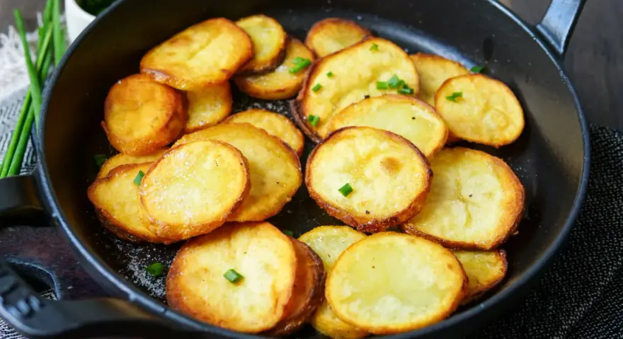 Goldbraune Bratkartoffeln mit Salz und Schnittlauch in einer Pfanne. Ein einfaches Bratkartoffeln Rezept für jeden Tag.