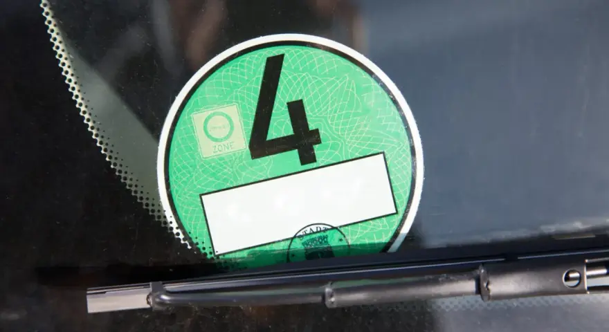 Grüne Umweltplakette mit der Nummer 4. Diese zeigt, welche Schadstoffklasse ist gut für die Umweltzone.