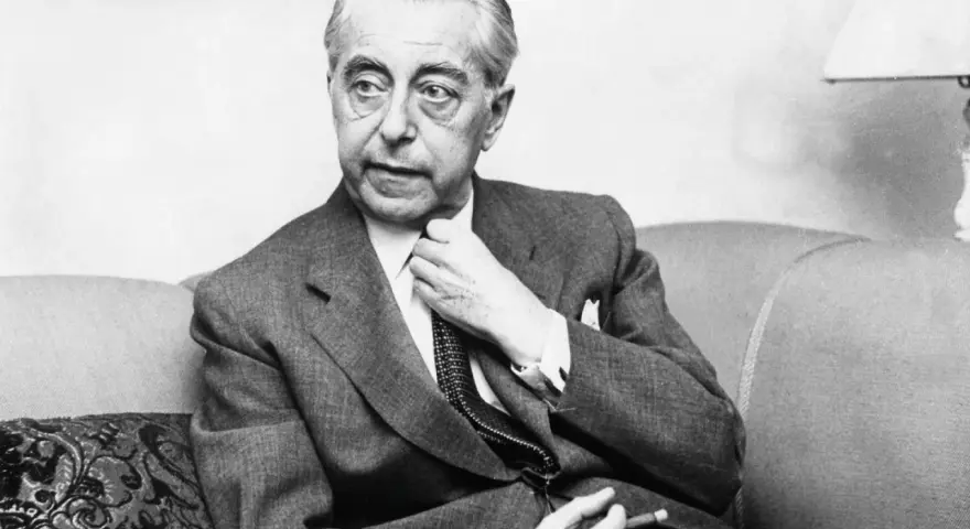 Hjalmar Gullberg, en av Sveriges mest älskade poeter, sitter i en fåtölj och justerar sin slips. Hans dikter fortsätter att beröra läsare.
