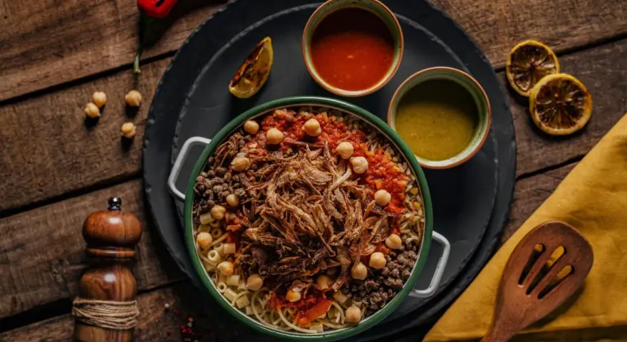 Kushari, narodowe danie kuchni egipskiej, z makaronem, ryżem, soczewicą, ciecierzycą, sosem pomidorowym i chrupiącą cebulką.