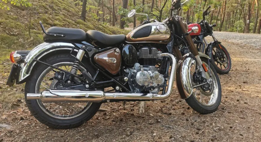 Royal Enfield Classic 350 dane techniczne: brązowy motocykl w lesie, obok czerwony. Klasyka i moc.