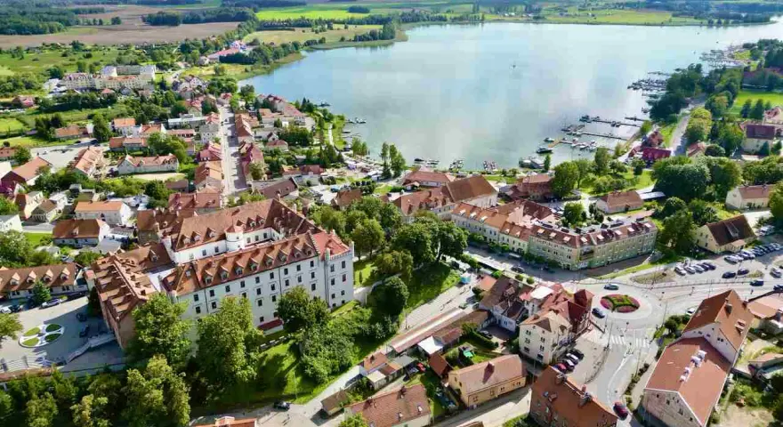 Widok z lotu ptaka na miasteczko nad jeziorem, z zamkiem i mariną. Idealne miejsce, gdzie na Mazury.