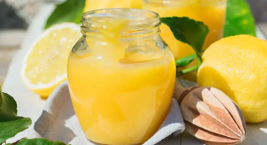 Un pot de lemon curd onctueux, prêt à être dégusté. Une recette simple pour un délice acidulé.