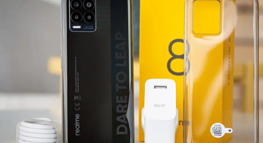 Zestaw z telefonem realme 8: czarny smartfon, ładowarka, kabel i przezroczyste etui.