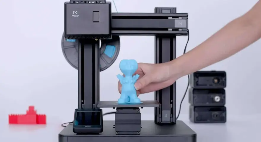 Drukarka 3D MOOZ tworzy niebieską figurkę. Zastanawiasz się, ile prądu zużywa drukarka 3D?