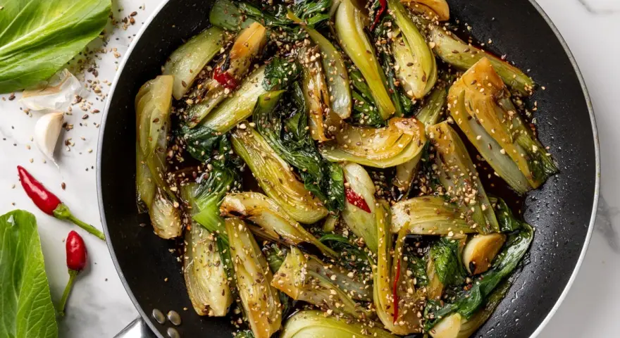 Verdure in padella, bok choy saltato con aglio, peperoncino e semi di sesamo, un piatto saporito e colorato.