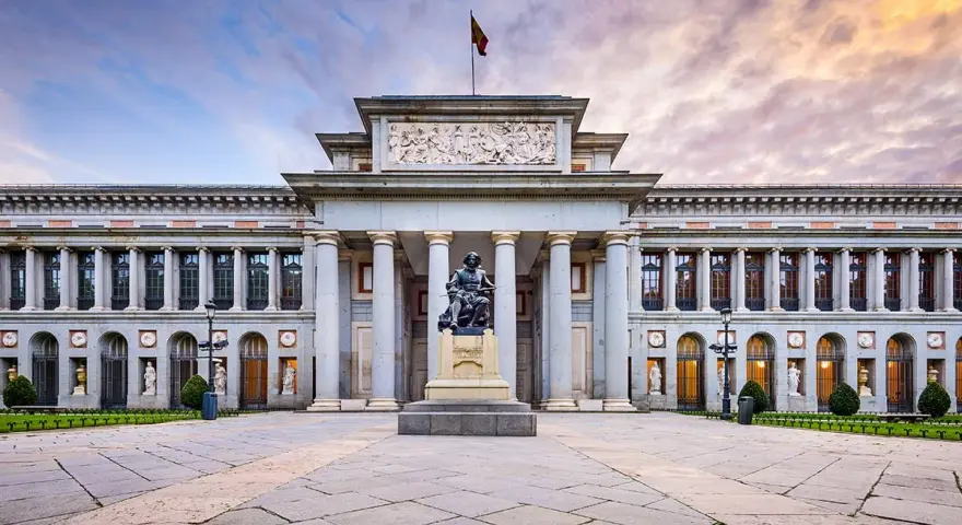 Przed majestatycznym muzeum w Madrycie, na placu z kamienną posadzką, stoi pomnik artysty.