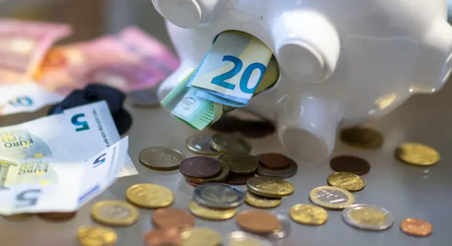 Sparschwein mit Euro-Scheinen und Münzen. Vielleicht reicht es bald für free now taxi preise.