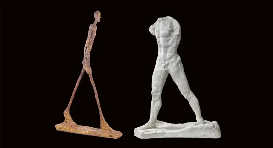 Deux sculptures d'hommes en mouvement : l'un fin et rouillé, l'autre blanc et musclé. L'homme qui marche, une figure intemporelle.