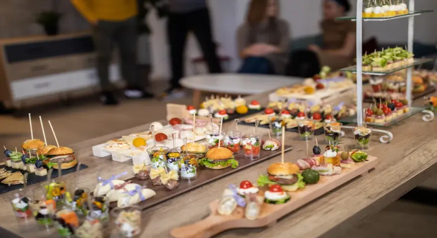 Stół pełen pysznych finger food: mini burgery, koreczki, przekąski w pucharkach. Idealne na imprezę!