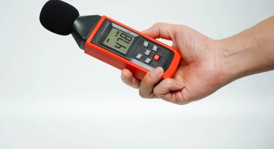 Main tenant une sonomètre pour savoir comment mesurer les décibels dans une pièce. L'appareil affiche 47.8 dB.