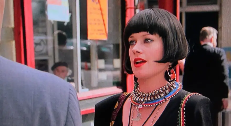 Melanie Griffith in un film, con un taglio di capelli a caschetto e un look audace.