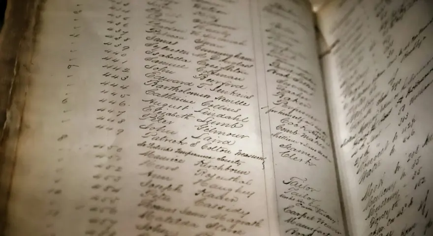 Vieille page d'un registre manuscrit, avec des noms et des chiffres. On y lit des noms comme "August Lindahl" et "Catherine Collins", évoquant un arbre généalogique ou un recensement ancien.