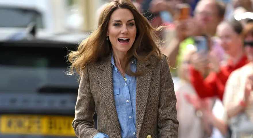 La principessa Kate sorride entusiasta tra la folla, con i capelli mossi dal vento. Le ultime notizie la vedono impegnata in un evento pubblico.