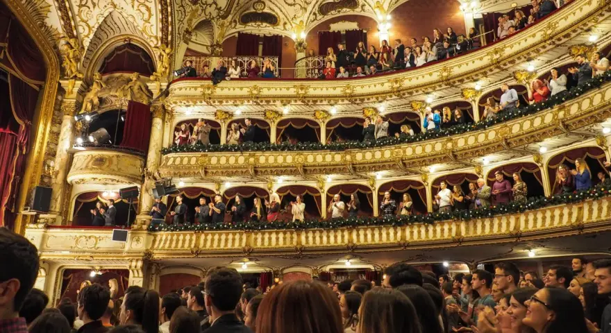 Ein prunkvolles Theater mit vielen Rängen, auf denen Zuschauer sitzen und applaudieren. Hier wird gerade gefragt: was ist eine Operette?