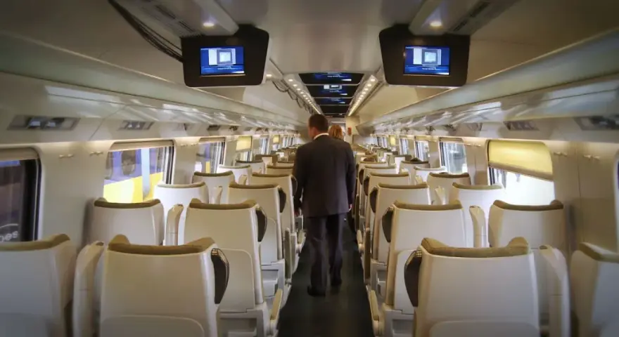 Wnętrze pociągu Pendolino. Para pasażerów idzie przez pusty wagon w drodze z Rzeszowa do Gdańska.