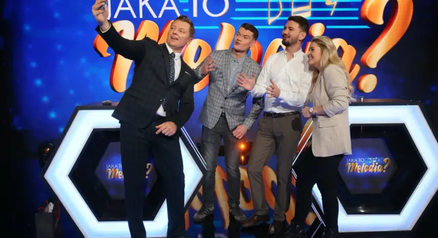 Jaka to melodia obsada robi sobie selfie. Uśmiechnięci uczestnicy pozują na tle scenografii z logotypem programu.