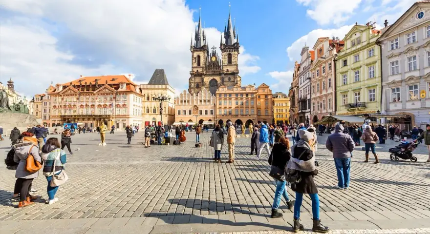 People enjoy Prague tours in Old Town Square, with the Church of Our Lady before Týn dominating the skyline.