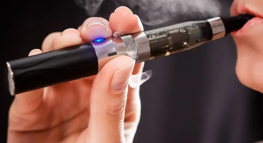 Persona usa un vaper saludable, exhalando vapor blanco.